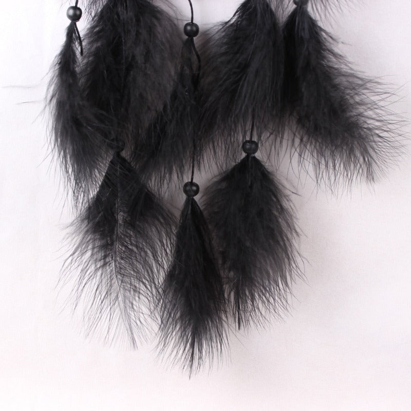 Un dreamcatcher avec des plumes noires et des perles noires.